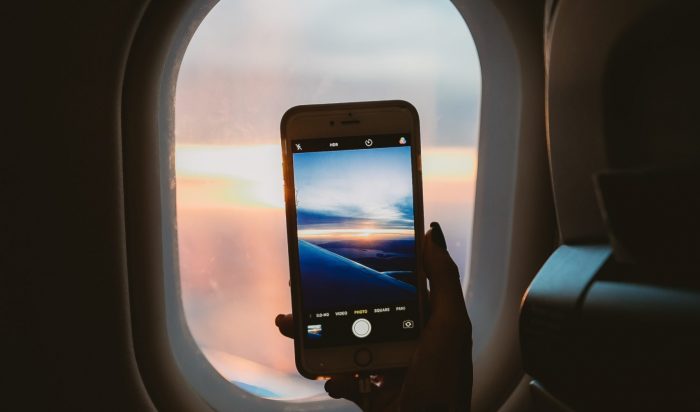 person-holding-smartphone-inside-airplane-1647116